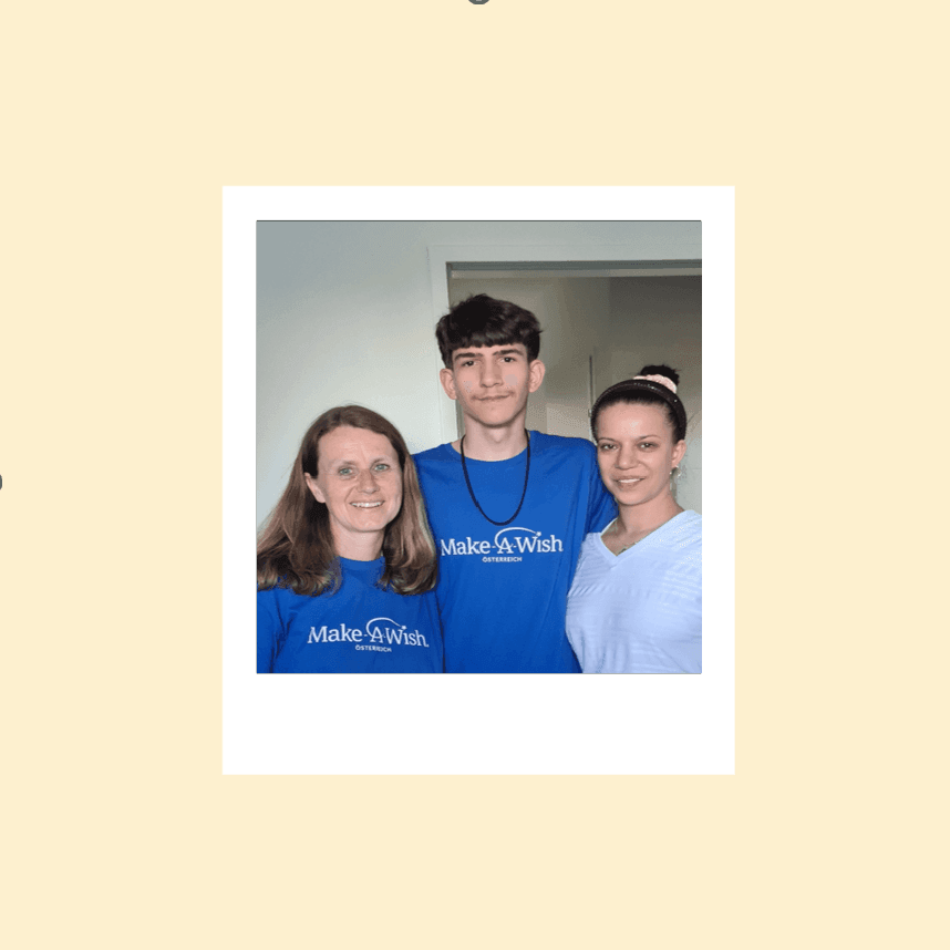 Three people standing together indoors, wearing blue Make-A-Wish t-shirts.